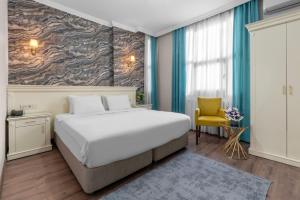 伊斯坦布尔瓦里德酒店的一间卧室配有一张大床和一张黄色椅子