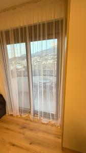 a window with white curtains and a table in a room at Luxury Home in Dobra Voda