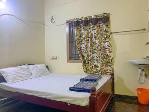 Ahobilam VPS NIVAS Guest House في Pedda Ahobilam: غرفة صغيرة بها سرير ونافذة