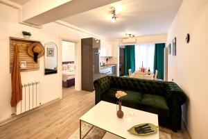 a living room with a green couch and a table at Nikola Apartment Infinity Resort in Mamaia