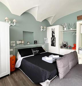 a bedroom with a black bed and a couch at COTTON CANDY TORTELLINOSUITE Modena in Modena
