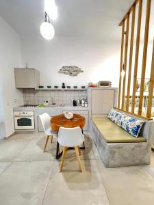 a kitchen with a table and a couch in a room at Gerani Deluxe Houses in Astypalaia
