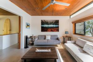 a living room with a couch and a ceiling fan at Casa Colibri - Stunning ocean view in Santa Teresa Beach +76 photos