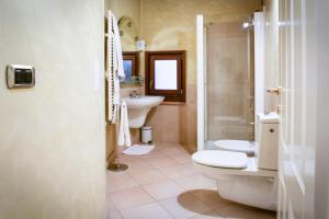 y baño con 2 aseos, lavamanos y ducha. en Aparthotel ANTICO SAN ZENO centro storico, en Verona