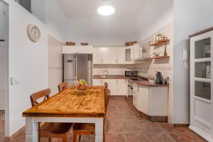 una cocina con una mesa de madera con sillas y una mesa sidx sidx sidx sidx en Casa Eusebia, en Arona