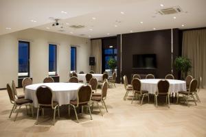a conference room with tables and chairs and a screen at Resident City Hotel in Almaty