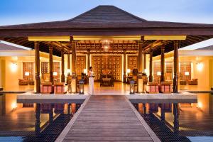 a villa with a boardwalk leading to a swimming pool at Anantara Peace Haven Tangalle Resort in Tangalle