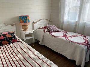 sypialnia z dwoma łóżkami i stołem z lampą w obiekcie maison chaleureuse w mieście Le Château-dʼOléron