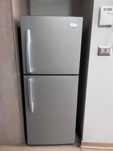 サンティアゴにあるDepartamento Santiagoの壁の隣のキッチンにある銀製の冷蔵庫