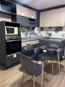 サンティアゴにあるDepartamento Santiagoのキッチン(ガラステーブル、電子レンジ付)