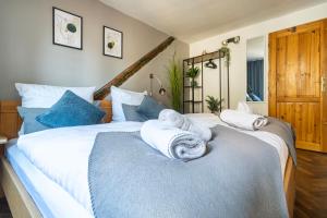 two beds in a bedroom with towels on them at 20 seconds to Charles Bridge in Prague