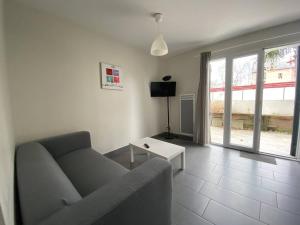 a living room with a couch and a table at T1 bis confortable avec parking et animaux acceptés - FR-1-495-111 in Cambo-les-Bains