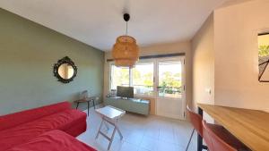 a living room with a red couch and a table at Residencial Las Dunas, Best Holiday Home Resort On The Island- VV in Corralejo