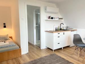 a small white kitchen with a sink and a desk at Quiet, green, relaxing place - 1 bedroom apartment in Balatonfüred