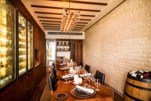 a restaurant with wooden tables and chairs and a chandelier at Anantara Peace Haven Tangalle Resort in Tangalle