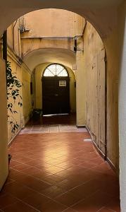 an empty hallway with a black door and a tile floor at ITALIA HOUSE TORTELLINOSUITE Modena in Modena