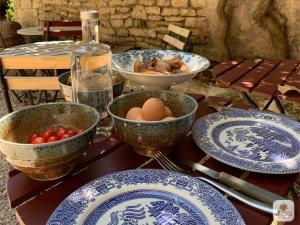 a table with blue and white plates and eggs on it at Algranate - Maison du Tisserand in Flavigny-sur-Ozerain