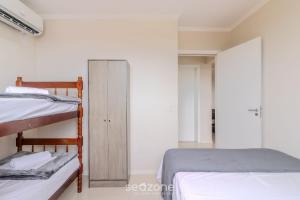 a bedroom with two bunk beds and a closet at Prédio com piscina a 400m da Praia - LEA in Piçarras +17 photos