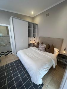 a bedroom with a large bed with white sheets and pillows at Bloom and Berry Cottage in Hallack Rock