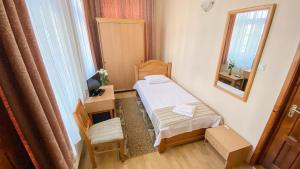 a small room with a bed and a mirror at Hotel Regal in Brăila