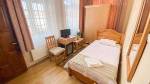 a small bedroom with a bed and a television at Hotel Regal in Brăila