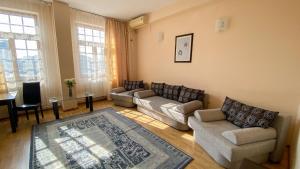 a living room with couches and a table and windows at Hotel Regal in Brăila +34 photos
