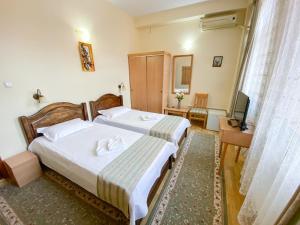 a hotel room with two beds and a television at Hotel Regal in Brăila