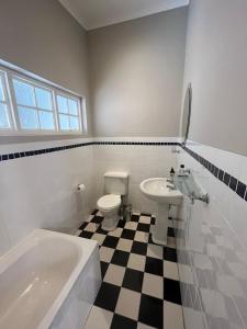 a bathroom with a sink and a tub and a toilet at Bloom and Berry Cottage in Hallack Rock