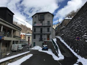 a building with a car parked on a snowy street at Appartement n° 32 in Barèges