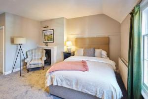 Book Whole Aparthotel - Sleeps 18 - Exclusive Use - by PureStay - Free Parking في ماتش وينلوك: غرفة نوم بسرير وكرسي ومدفأة