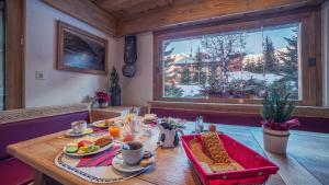 una mesa con comida en ella en una habitación con ventana en Hotel Mirabeau en Verbier