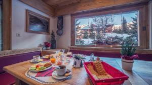 einen Tisch mit Essen drauf in einem Zimmer mit Fenster in der Unterkunft Hotel Mirabeau in Verbier