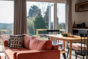 a living room with a couch and a table at Murmur y Coed in Newborough