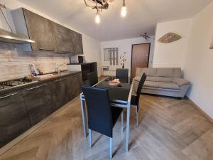 a kitchen and living room with a table and chairs at Manuel Guesthouse Arta terme in Arta Terme