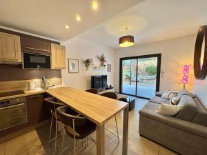 a kitchen and living room with a table and a couch at Rena Bianca tout confort proche plage et centre ville in Propriano