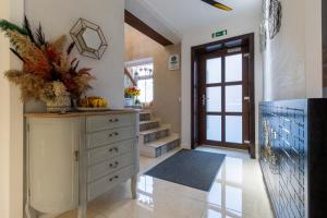 a room with a dresser with a door and aoyer with stairs at Lumiere House Sibiu in Sibiu