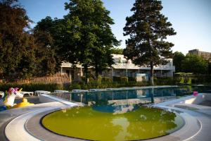 a pool of green water in a park at Hotel Iulia Resort in Venus