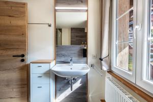 a bathroom with a sink and a mirror at Gasthaus zur Linde und Fewo in Menzenschwand +108 photos