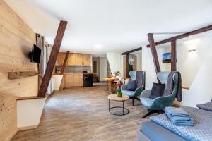 a living room with a couch and chairs and a kitchen at Gasthaus zur Linde und Fewo in Menzenschwand