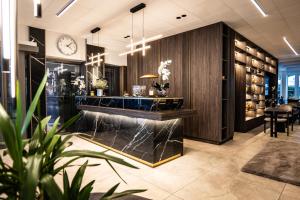 a lobby with a counter and a clock on the wall at Hotel & Restaurant Knote in Sindelfingen