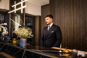 a man in a suit standing in front of a counter at Hotel & Restaurant Knote in Sindelfingen