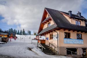 a building with snow on the ground in front of it at U Justynki in Małe Ciche