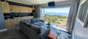 a living room with a couch and a large window at Hartklop Luxury Self Catering Guesthouse in Linkside