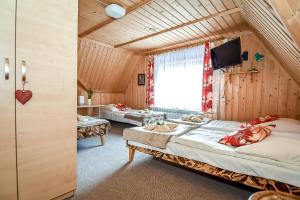 a room with two beds and a tv in it at U Justynki in Małe Ciche +65 photos