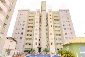 a large building with a swimming pool in front of it at Prédio com piscina a 400m da Praia - LEA in Piçarras