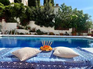 a pool with two pillows and a bowl of fruit on a table at Villa Mara in Caleta De Velez
