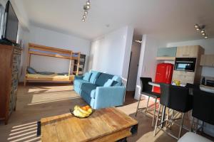 Una sala de estar con un sofá azul y una mesa. en La Falaise by Tranquil at Home, en Pornichet