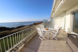 Un balcón con mesa y sillas y el mar. en La Falaise by Tranquil at Home, en Pornichet 7 fotos más