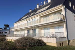 Un edificio blanco con un balcón al costado. en La Falaise by Tranquil at Home, en Pornichet
