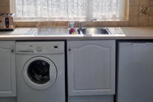 a kitchen with a sink and a washing machine at Doncaster-House-Sleeps8-Parking-Garden in Doncaster